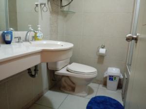 y baño con aseo, lavabo y ducha. en Casa Marite en Lima