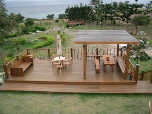 a wooden deck with a table and chairs and an umbrella at Knt House in Chenggong