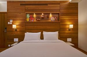 a bedroom with a large bed with wooden walls at Hotel Atharv Top Rated Business Hotel in Kolhapur in Kolhapur