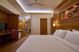 a hotel room with a large bed and a desk at Hotel Atharv Top Rated Business Hotel in Kolhapur in Kolhapur
