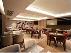 Guangzhou City Join Hotel Shipai Qiao Branch في قوانغتشو: غرفة طعام مع طاولات وكراسي في مطعم