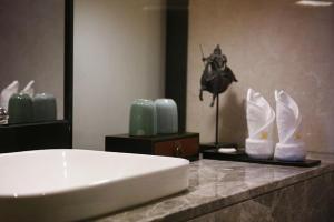 a bathroom with a counter with a sink and vases at Guangzhou City Join Hotel Shipai Qiao Branch in Guangzhou