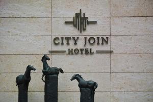 a building with three statues of horses in front of it at Guangzhou City Join Hotel Shipai Qiao Branch in Guangzhou