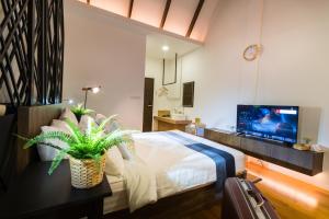 a bedroom with a bed and a tv on a wall at Siam Nitra Boutique Hotel in Bangkok