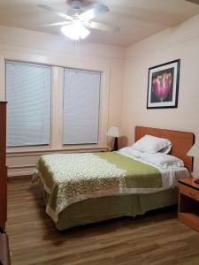 a bedroom with a bed and two windows at Boston Hotel in San Francisco