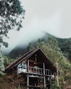 a large wooden structure with a view of a mountain range at Sembalun Kita Cottage in Sembalun Lawang