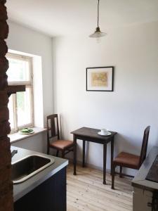 cocina con fregadero, mesa y sillas en Vintage Design Apartment, en Kuldīga