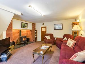 sala de estar con sofá rojo y chimenea en Curradoon House, en Ballynamult