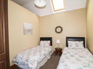 1 dormitorio con 2 camas y ventana en Rosemount Coach House, en Ballycarney