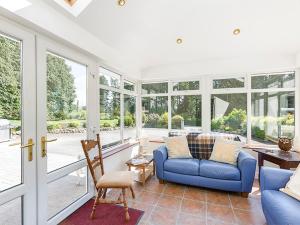 sala de estar con sofá azul y ventanas en Curradoon House, en Ballynamult