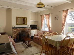 uma sala de estar com uma mesa e um sofá em Brandy Harbour Cottage em Kilcolgan