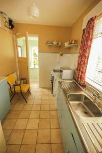 a kitchen with a sink and a tiled floor at Teach Annie in Falcarragh