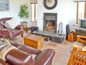 sala de estar con sofá y chimenea en Finn House en Castlegregory