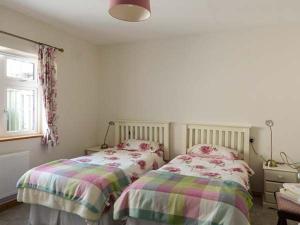 um quarto com 2 camas individuais e uma janela em Brandy Harbour Cottage em Kilcolgan