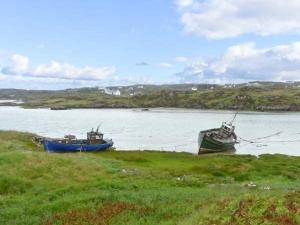 two boats sitting on the shore of a body of water at Lully More Cottage in Doochary