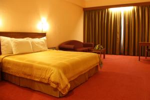Postel nebo postele na pokoji v ubytování Hotel Grand Continental Kuching