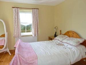a bedroom with a large bed and a window at The Bay in Caherdaniel