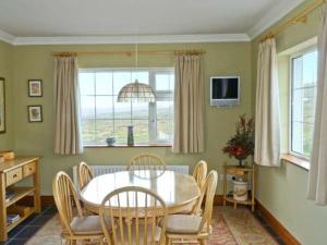 a dining room with a table and chairs and a window at Carraig Oisin in Waterville