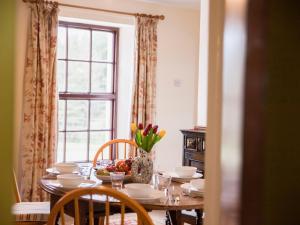a dining room table with a vase of flowers on it at Shepherds' Retreat in Greencastle