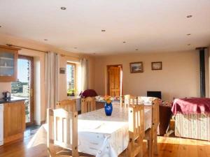 a kitchen and dining room with a table and chairs at Corr an Droma in Rossbrin