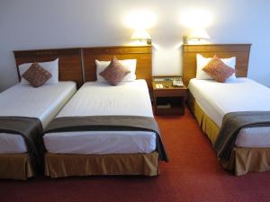Postel nebo postele na pokoji v ubytování Hotel Grand Continental Kuching