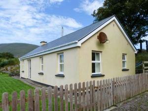 a small white house with a wooden fence at The Bay in Caherdaniel