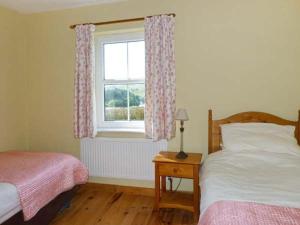 sypialnia z 2 łóżkami i oknem w obiekcie The Bay w mieście Caherdaniel