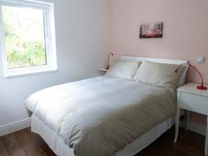 um quarto com uma cama, uma secretária e uma janela em Loistin Coimin em Ballybofey