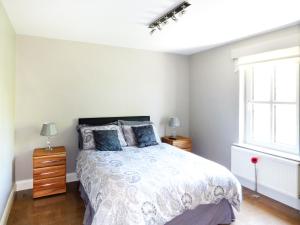 1 dormitorio con cama y ventana en Hidden Gem Cottage, en Dungloe