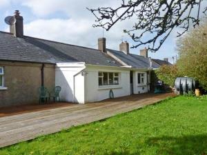 a house with a wooden deck in front of it at Burke Cottage in Lismore