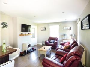 sala de estar con sofá y 2 sillas en Hidden Gem Cottage, en Dungloe