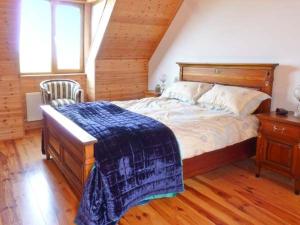 Un dormitorio con una cama con una manta azul. en Finn House en Castlegregory