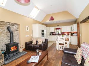 a living room with a fireplace and a stove at Rosemount Coach House in Ballycarney