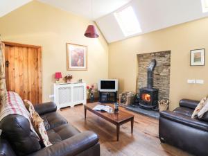 sala de estar con sofá y chimenea en Rosemount Coach House, en Ballycarney