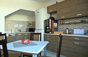 a kitchen with a white table with chairs and a kitchen gmaxwell gmaxwell gmaxwell at Sugó Panzió in Baja