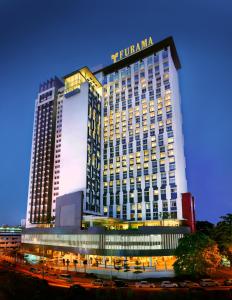 a tall building with a lit up sign on it at Furama Bukit Bintang, Kuala Lumpur in Kuala Lumpur