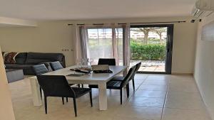 a dining room table with chairs and a laptop on it at Fantástico Chalet Adosado de lujo "Un Salto al Paraíso" in Sant Jordi