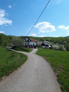 a dirt road leading to a house in a field at Guesthouse Andja in Smoljanac