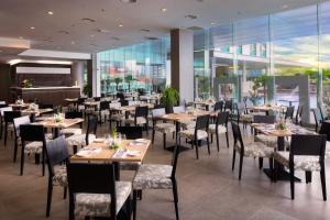 a restaurant with tables and chairs and windows at Furama Bukit Bintang, Kuala Lumpur in Kuala Lumpur +24 photos