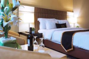 a hotel room with a bed and a table with a bottle of wine at Nagoya Mansion Hotel and Residence in Nagoya