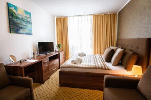 a hotel room with a bed and a television at Hotel Merkur in Kaluža