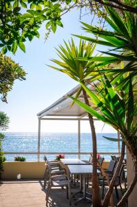 Marine du Miomo的住宿－圖爾瑪爾酒店，一张桌子和椅子,背景是大海