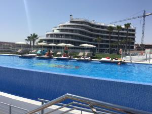 une grande piscine avec un grand bâtiment en arrière-plan dans l'établissement Infinity View, à Arenales del Sol