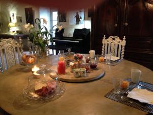 a table with food and candles on it with a piano at Le Relais de Roquefereau in Penne-dʼAgenais