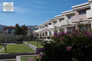 a row of apartment buildings with purple flowers at Xanthippi Hotel in Souvala
