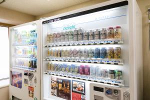 a refrigerator filled with lots of cans of soda at U-Community Hotel in Osaka