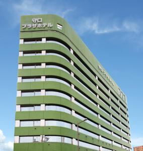 ein hohes, grünes Gebäude mit einem Schild drauf in der Unterkunft Osaka Moriguchi Plaza Hotel in Osaka