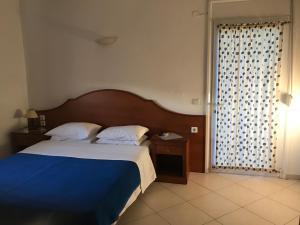 a bedroom with a bed with a blue blanket and a window at Agnanti in Ávdhira +16 photos