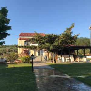 a building with a table and chairs in the grass at Agnanti in Ávdhira