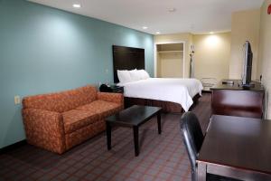 a hotel room with a bed and a couch at Ranger Inn & Suites in Arlington